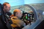 Mr. Dave Kirkland, a T-6 Texan simulator instructor, orients Lt. Col. Abdelfattah Ben Moussa, Moroccan Air Force, to a T-6 Texan flight simulator as part of his Randolph distinguished visitor tour April 4. Colonel Ben Moussa, a member of the Moroccan T-6 acquisition team, visited Randolph to become familiar with the aircraft and its use as a trainer. (U.S. Air Force photo by Rich McFadden)