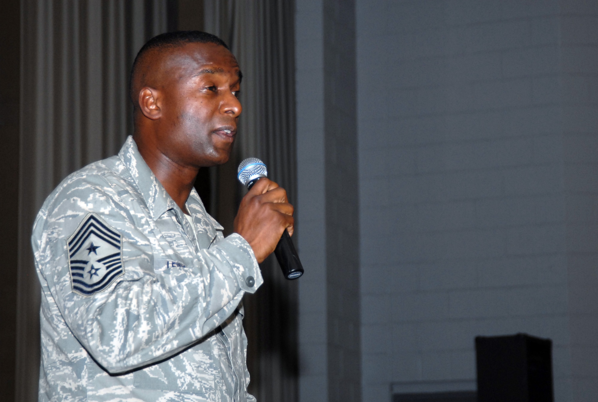 Chief Master Sgt. Juan Lewis, 95th Air Base Wing command chief, talks to Edwards Airmen and Marines during the basewide enlisted call at the base theater here April 15. This was Chief Lewis' last enlisted call before he moves on to Lackland Air Force Base, Texas. (Air Force photo by Senior Airman Julius Delos Reyes)