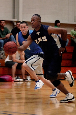 Kenneth Clinton dribbles down the court past Wesley Glatfelter at the Charleston AFB Fitness and Sports Center Tuesday. Clinton plays for the 437 LRS and Glatfelter plays for the 437 MXS.  (U.S. Air Force photo/Senior Airman Nicholas Pilch)