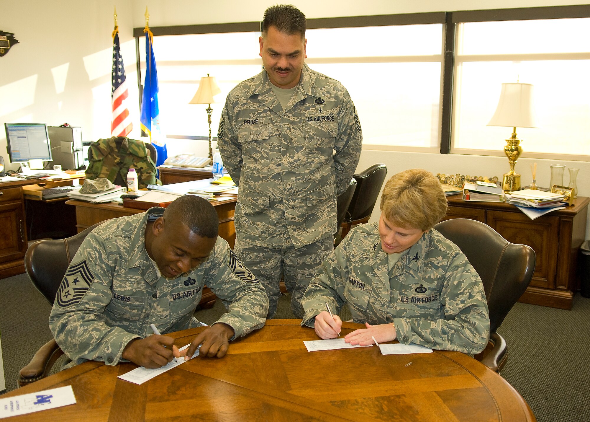 Col. Nancy Wharton (right), 95th Air Base Wing commander, and Chief Master Sgt. Juan Lewis (left), 95th ABW command chief, fill out their donation slips for the Air Force Assistance Fund here April 16 as Master Sgt. John Price (standing), 95th ABW AFAF representative, looks on. The AFAF campaign was established to provide an annual effort to raise funds for affiliates that gives assistance to Air Force active-duty personnel, retirees, Reservists, Guardsmen and family members. (Air Force photo by Mike Cassidy)