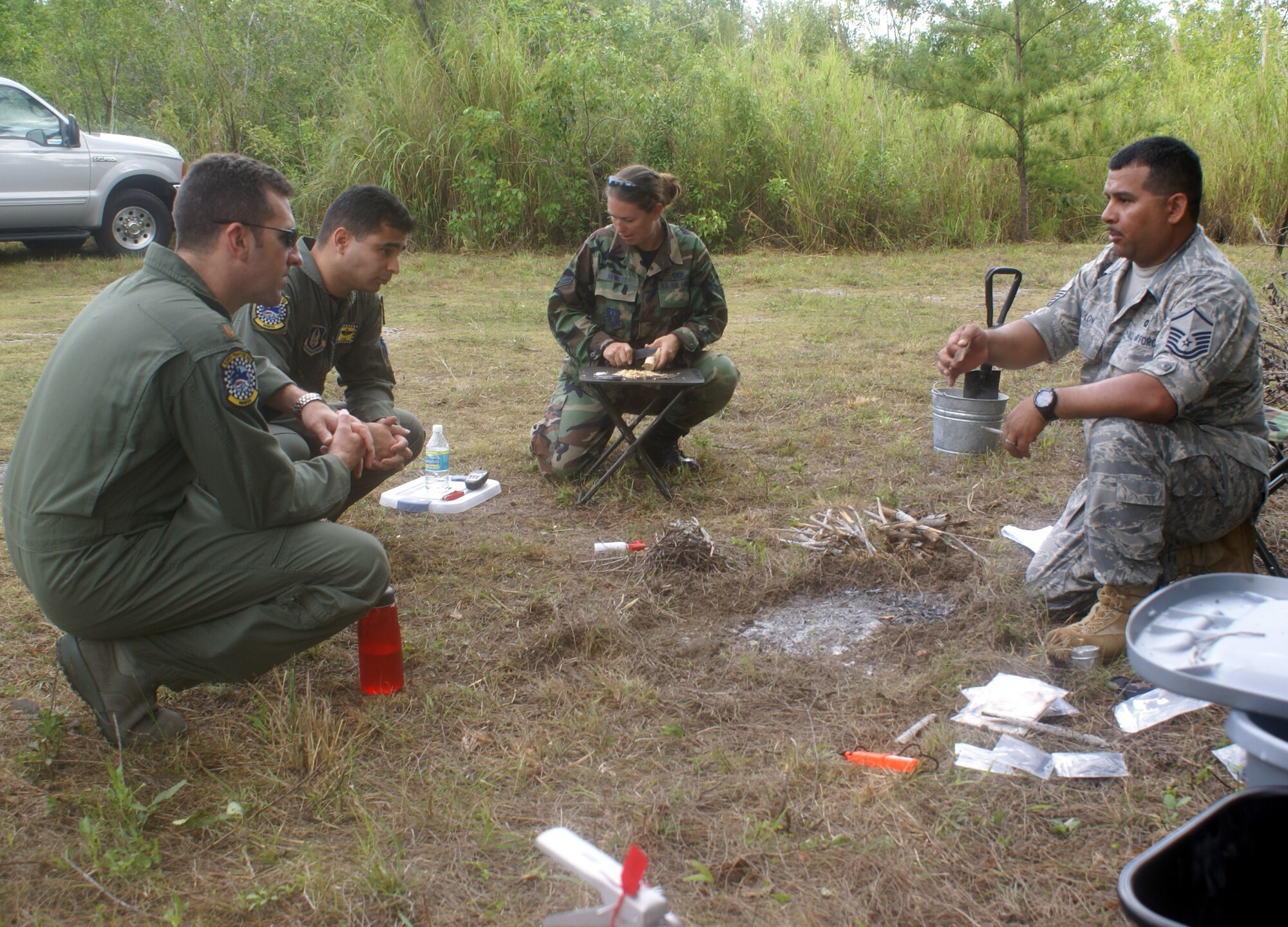 HOMESTEAD AIR RESERVE BASE, Fla. -- Master Sgt. Jay Colon (right) and Airman 1st Class Kristina Hewett (center), 93rd Fighter Squadron Life Support technicians, teach 93rd FS pilots how to build and maintain fires in an isolated environment during Combat & Water Survival training on April 12-13. Life Support personnel and a Survival, Evasion, Resistance and Escape (SERE) instructor also taught lessons on water survival, electronic and visual signaling, building shelter, personal protection, food and water procurement, and camouflage, evasion and navigation. (U.S. Air Force photo/Senior Airman Erik Hofmeyer)
