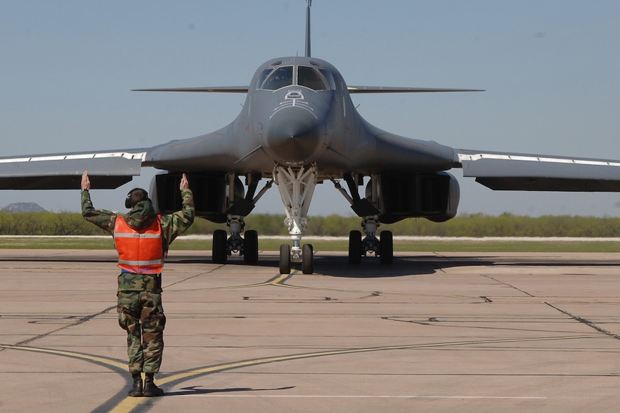 DYESS AIR FORCE BASE, Texas-- Airman Rocky Lewis, 7 Aircraft Maintenance Squadron, marshals a B-1 out of his parking spot so he can prepare for takeoff April 15. Airman Lewis is an avionics instruments specialist, but the 7 AMXS cross utilization trains their Airman to do multiple jobs.(U.S Air Force photo by Senior Airman Felicia Juenke)