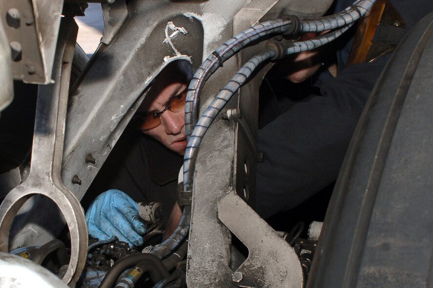 DYESS AIR FORCE BASE, Texas-- Airman 1st Class Thomas Hulsart, 7 Aircraft Maintenance Squadron, inspects the attachment point for the axel beam positioner on the B-1 April 15. The inspection is done to ensure there is no debris or cracks that will prevent the crew chiefs from accurately reattaching the axel beam positioner.(U.S Air Force photo by Senior Airman Felicia Juenke)