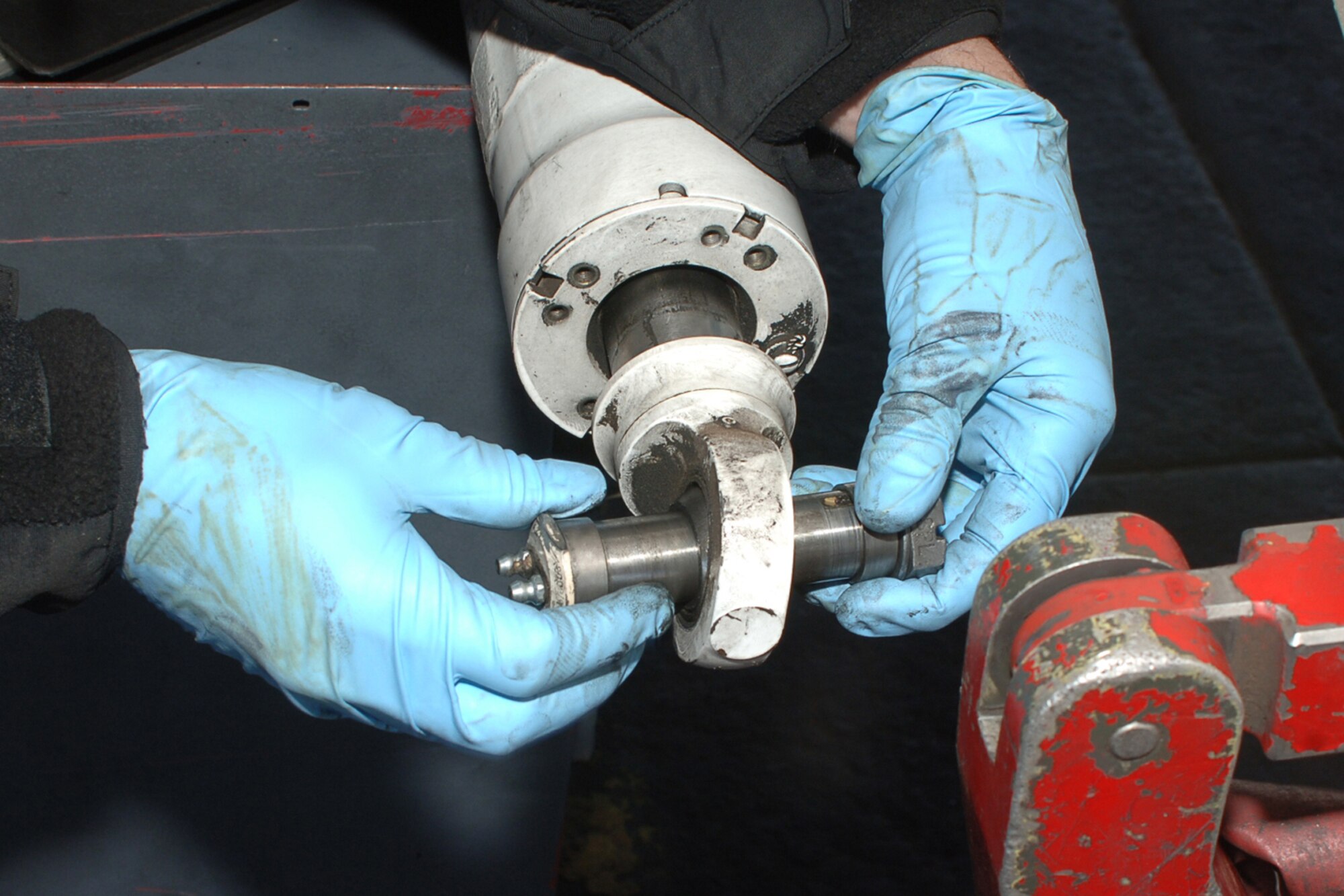 DYESS AIR FORCE BASE, Texas-- Airman 1st Class Thomas Hulsart, 7 Aircraft Maintenance Squadron, adjusts the attachment bolt for an axel beam positioner, while working on a B-1 April 15. The axel beam positioner is used to keep the landing gear level.(U.S Air Force photo by Senior Airman Felicia Juenke)