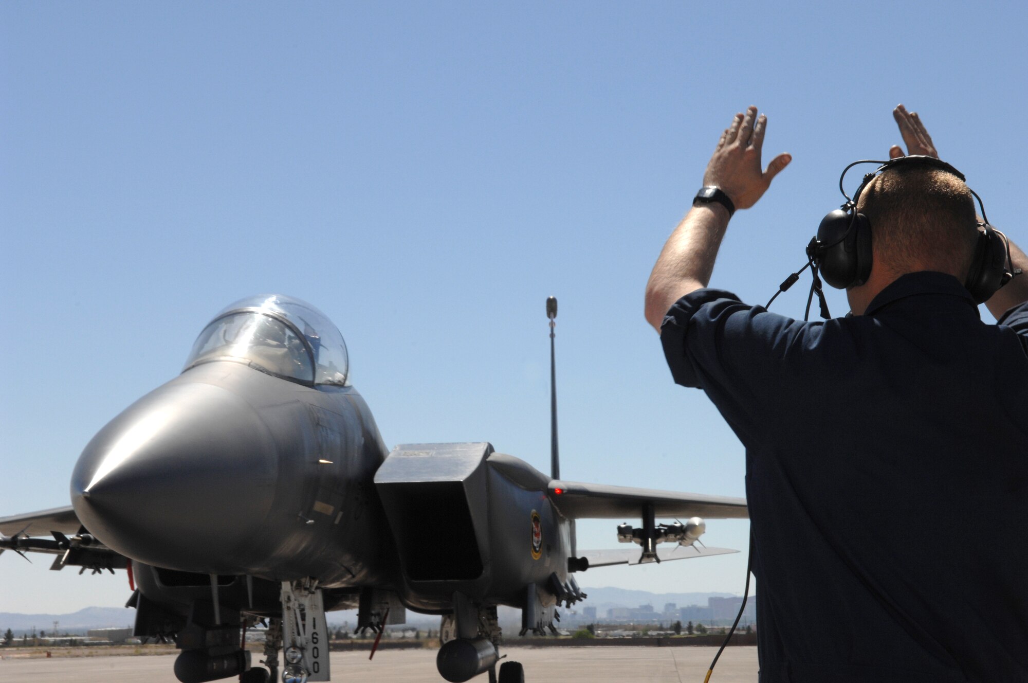 MOUNTAIN HOME AIR FORCE BASE, Idaho -- Senior Airman Chris Bell, 391st Aircraft Maintenance Unit dedicated crew chief, marshals an F-15E Strike Eagle down the flightline after it returned from a training mission April 9 at Nellis AFB, Nev. The 391st Fighter Squadron is at Nellis until May 2 to provide support for aircrews training at the United States Air Force Weapons School. The 366th Fighter Wing supports the weapons school every two years. (U.S. Air Force Photo/ Senior Airman Larry E. Reid Jr.)
