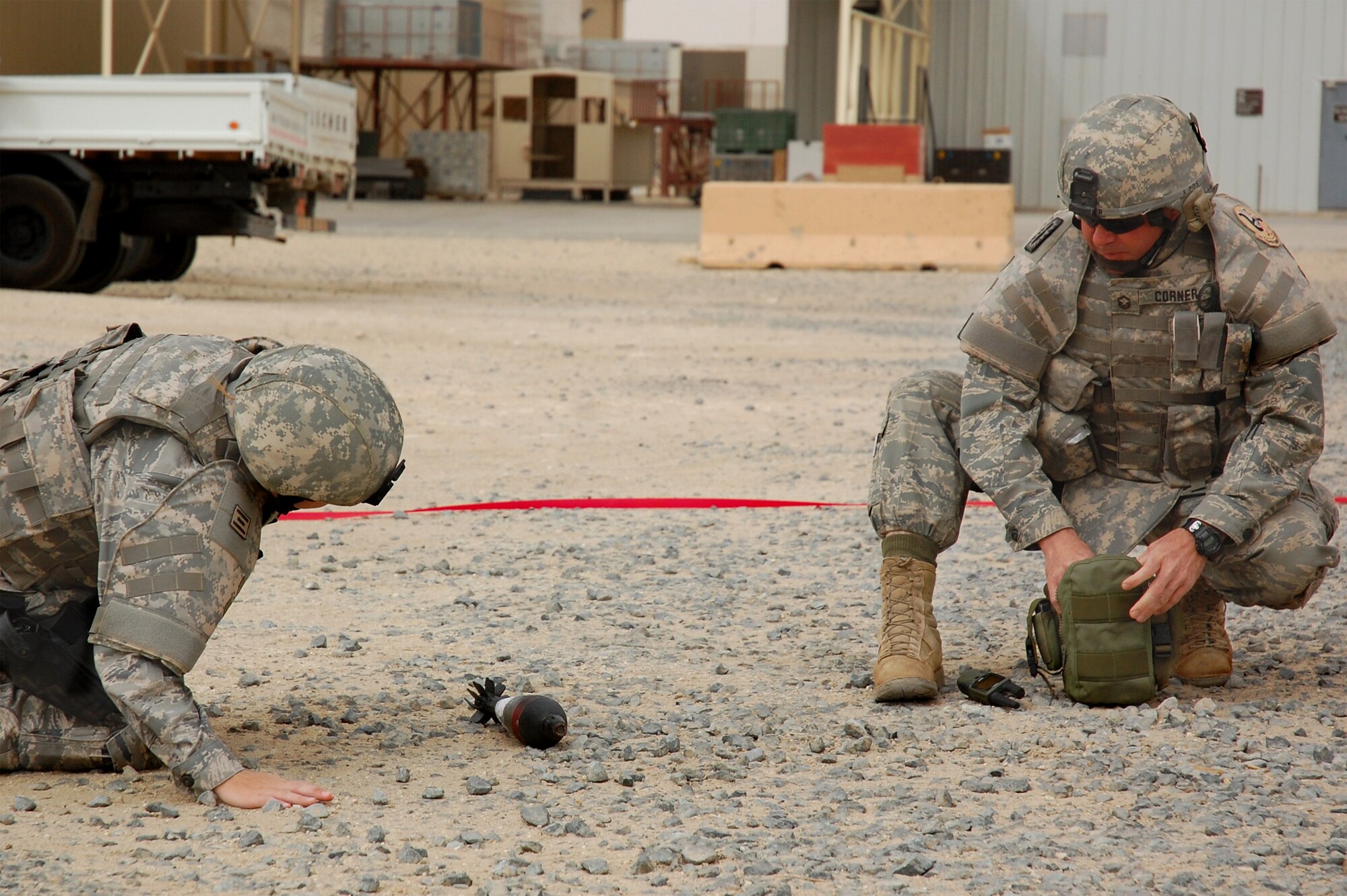 SOUTHWEST ASIA -- Airman 1st Class Jessica Ogilbee (left) and Senior Master Sgt. Russell Corner, both from the 386th Expeditionary Civil Engineer Squadron explosive ordnance disposal flight, examine a simulated unidentified explosive ordnance during a battle drill April 09, 2008, on an air base in the Persian Gulf Region. Colonel Robert Swisher, 386th Air Expeditionary Wing commander, continually tests the combat readiness and response capabilities of the Airmen in the wing. (U.S. Air Force photo/ Staff Sgt. Patrick Dixon)