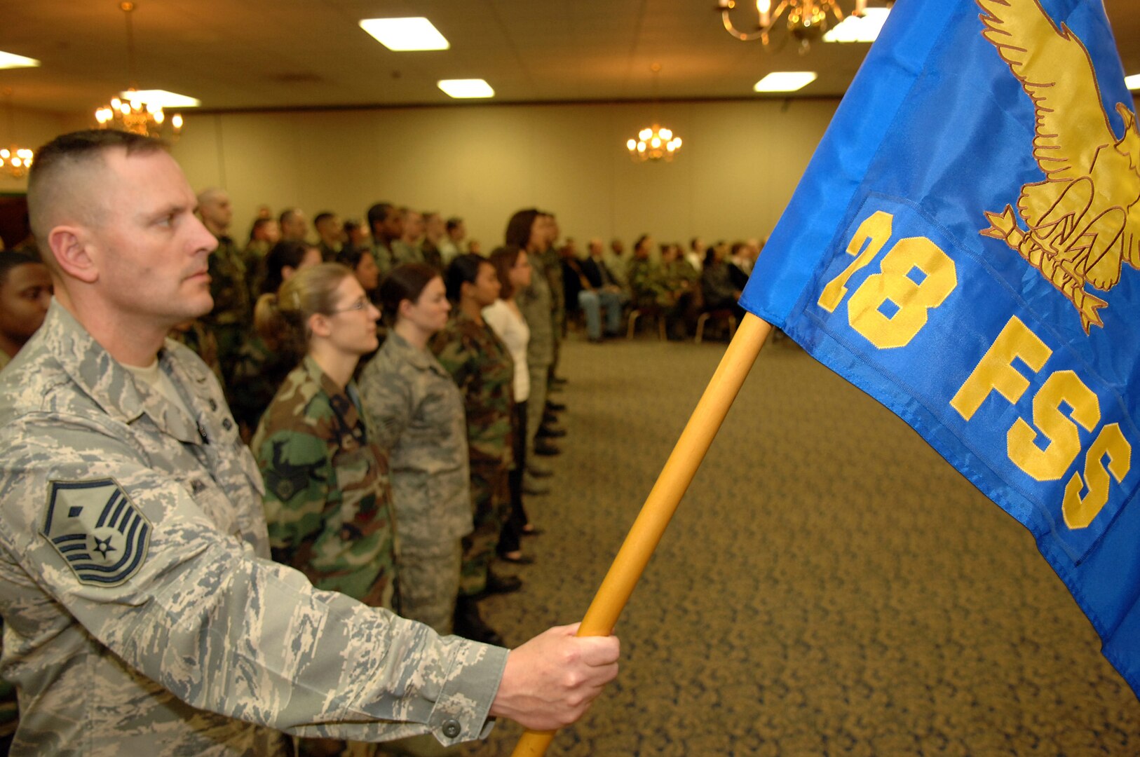 Master Sgt. Chris Morgan, 28th Force Support Squadron first sergeant, holds the new squadron guidon during the FSS activation ceremony at Dakota's on April 11. The FSS was formed by combining the 28th Services Squadron and the 28th Mission Support Squadron. (U.S. Air Force photo/Senior Airman Marc I. Lane) 
