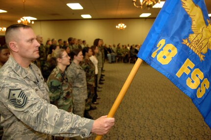 Master Sgt. Chris Morgan, 28th Force Support Squadron first sergeant, holds the new squadron guidon during the FSS activation ceremony at Dakota's on April 11. The FSS was formed by combining the 28th Services Squadron and the 28th Mission Support Squadron. (U.S. Air Force photo/Senior Airman Marc I. Lane) 
