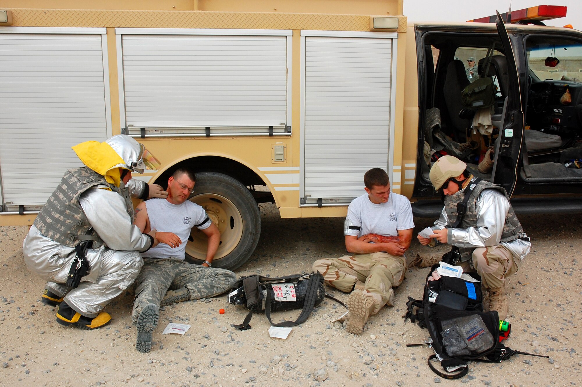 SOUTHWEST ASIA -- Staff Sgt. Michael Crispin (left) and Senior Airman Jeremy Brush (far right), both fire fighters from the 386th Expeditionary Civil Engineer Squadron, administer first aid to Airmen with simulated wounds April 09, 2008, during a battle drill on an air base in the Persian Gulf Region. Colonel Robert Swisher, 386th Air Expeditionary Wing commander, continually tests the combat readiness and response capabilities of the Airmen in the wing. (U.S. Air Force photo/ Staff Sgt. Patrick Dixon)