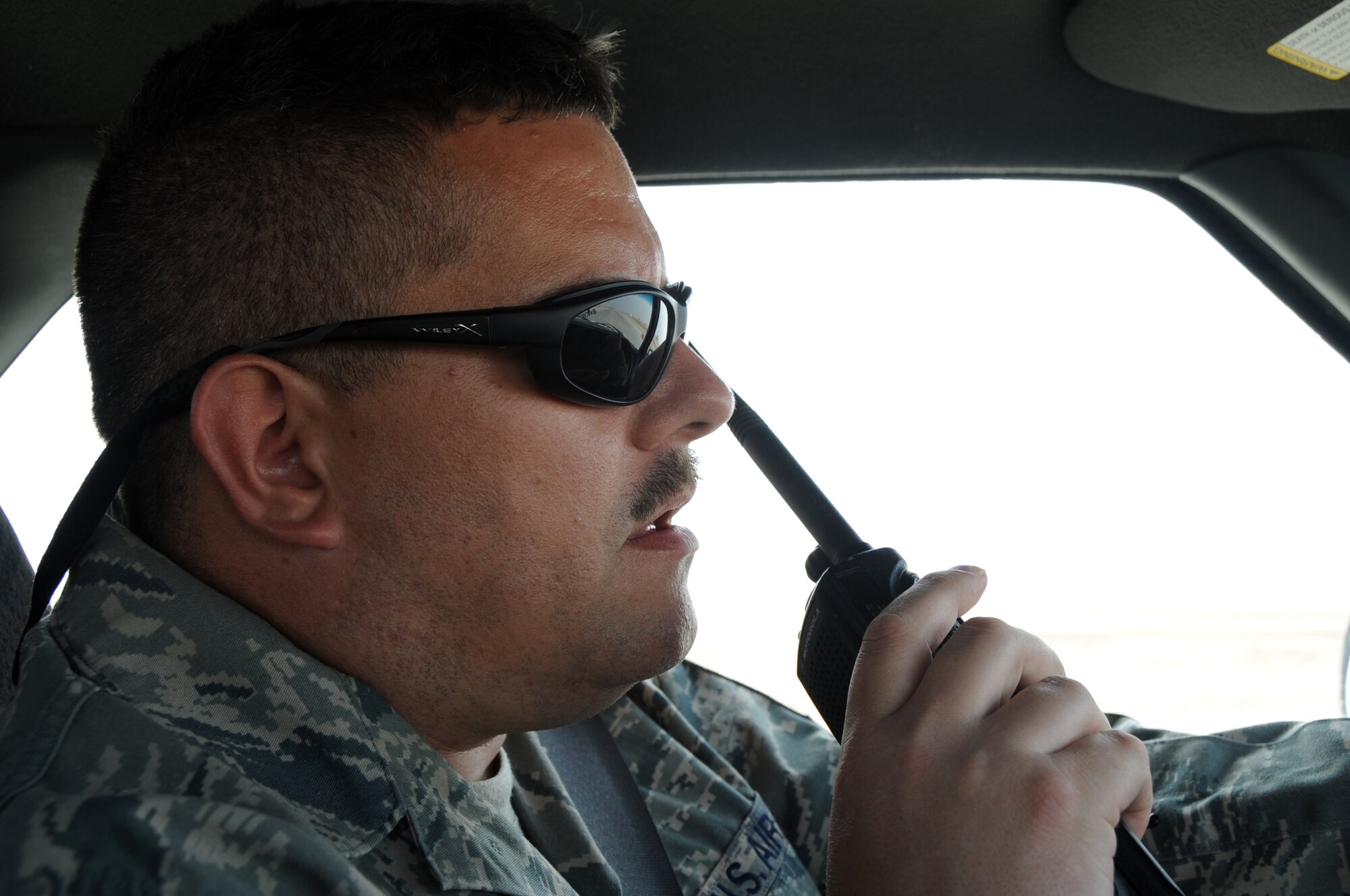 ALI BASE, Iraq -- Master Sgt. Matthew Smith, 407th Expeditionary Operations Squadron airfield manager, calls in a sweeper on the radio to clean off the taxiway immediately after the landing of a C17 here April 16.  A sweeper is sometimes called in after the landing of a heavy aircraft on Ali Base to ensure the airfield pavement remains FOD free. Sergeant Smith is deployed from McConnell AFB, Kan.  (U. S. Air Force photo / Tech. Sgt. Sabrina Johnson)