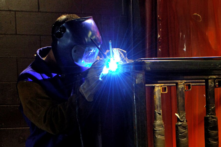 MINOT AIR FORCE BASE, N.D. -- Airman 1st Class Tom Johnson, 5th Maintenance Squadron, carefully welds a new door hinge onto a tire rack here April 9.  The welding shop takes safety seriously due to the weight of the materials that they handle and the crippling effects a welding arc can have on a person’s eye sight.  (U.S. Air Force photo by Airman 1st Class Kelly Timney)