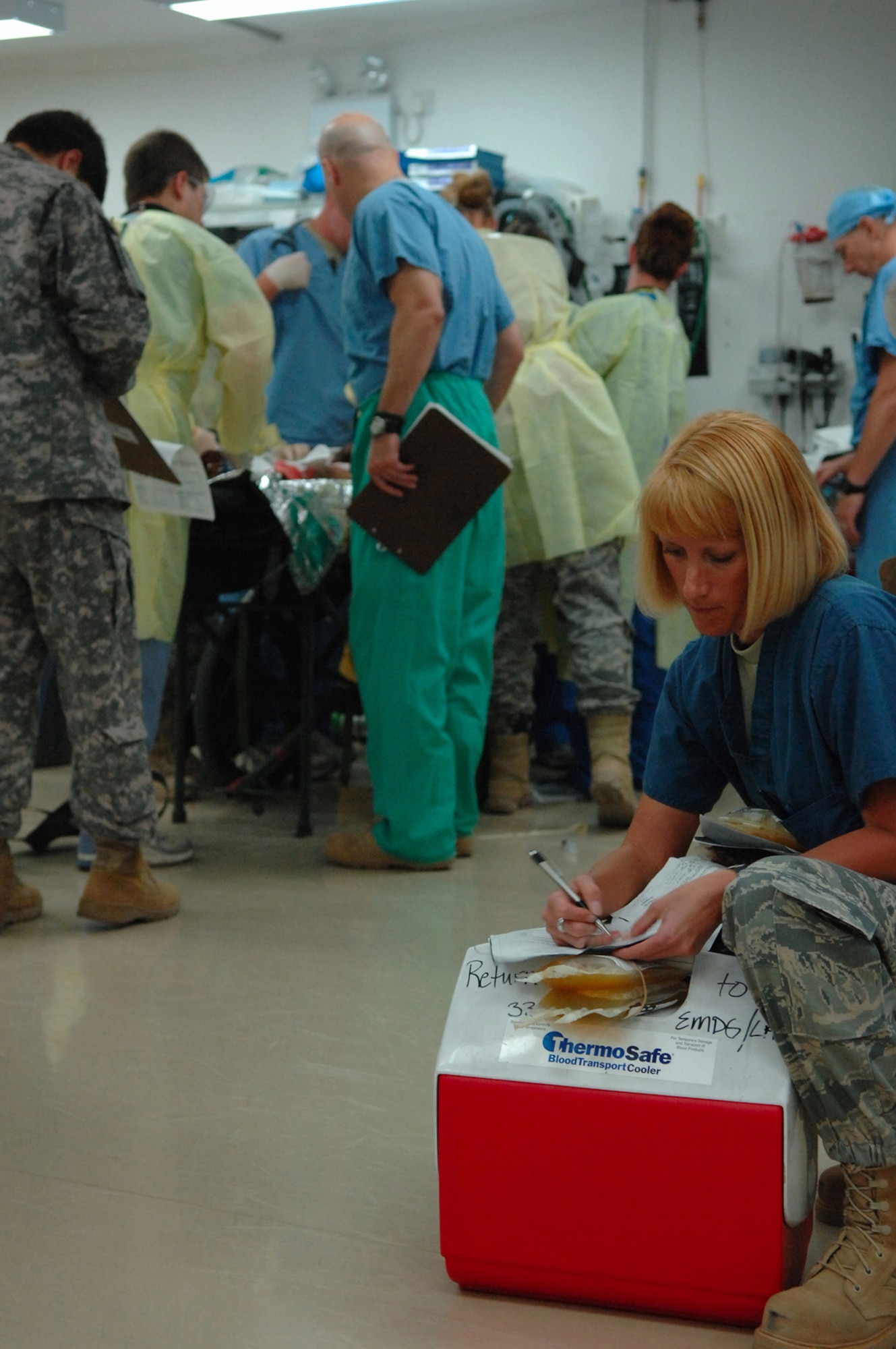 BALAD AIR BASE, Iraq -- Capt. Ronnie Leslie, 332nd Expeditionary Aeromedical Squadron laboratory officer in charge, annotates the amount and type of blood being administered to an Iraqi patient in the emergency room at the Air Force Theater Hospital here, April 15. Ten Iraqi adults were transported and admitted to the AFTH after being injured in a vehicle-borne improvised explosive device explosion in Baquba. Captain Leslie is deployed from Wright-Patterson Air Force Base, Ohio. (U.S. Air Force photo/ Senior Airman Julianne Showalter)