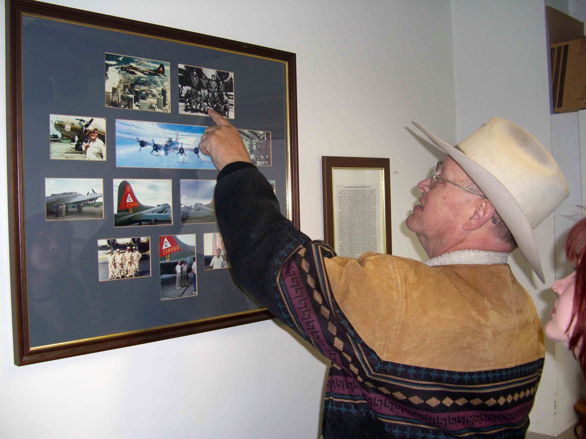 During his April 12, 2008 visit to RAF Molesworth, Mr. Jerry Carter spots his father then Staff Sgt. Edward K. Carter in a crew photo of the famous B17G "Thunderbird" of the 303rd Bomb Group (Heavy).  Mr, Carter's daughter Allison looks on.  (U.S. Air Force hoto by Peter Park)