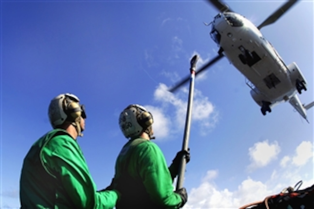 U.S. Navy Petty Officer 2nd Class Jeffrey Willey and Seaman Douglas Bennett hold a pendant to be hooked onto a Super Puma helicopter during a vertical replenishment, April 14, 2008, aboard the nuclear-powered aircraft carrier USS Nimitz, operating in the western Pacific and Indian oceans. 