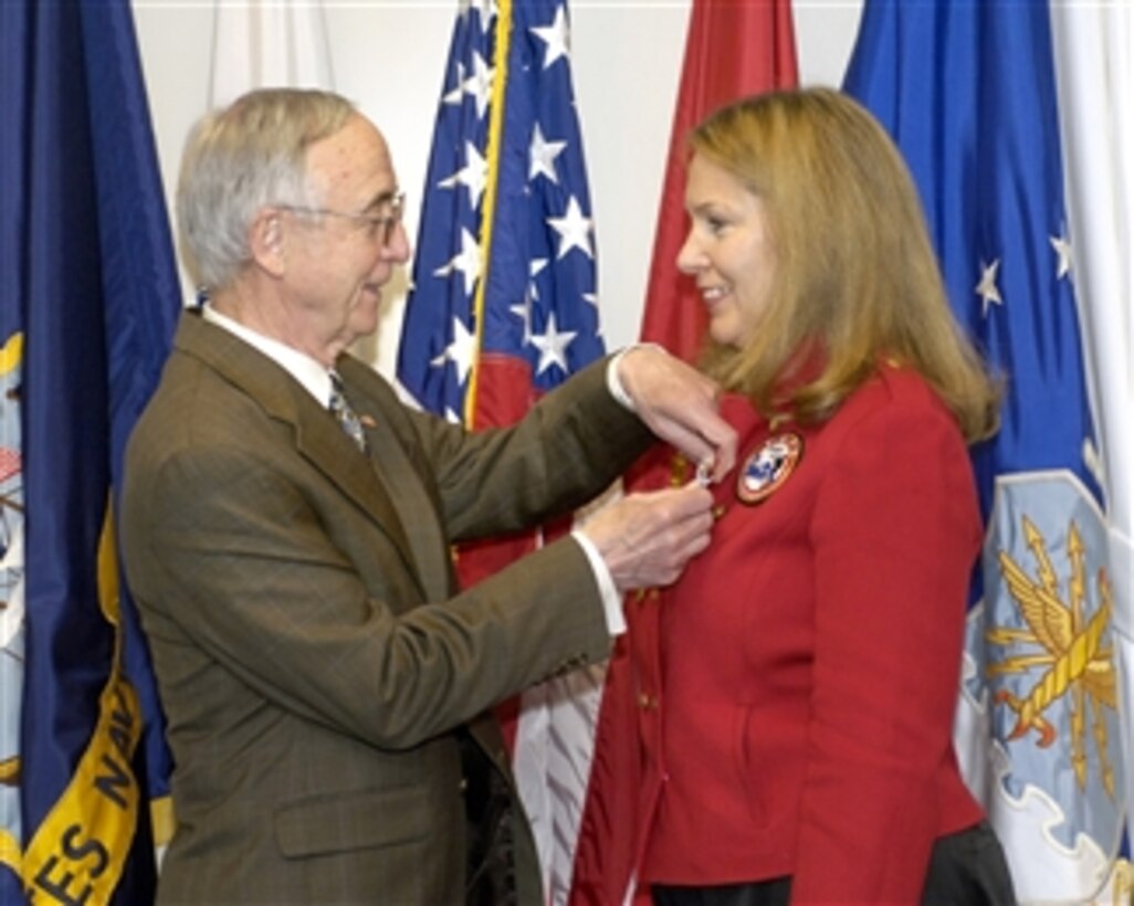 Deputy Secretary of Defense Gordon England (left) presents the Secretary of Defense Medal for Exceptional Public Service to the Founder and Director of the Tragedy Assistance Program for Survivors Bonnie Carroll in the Pentagon on April 15, 2008.  Carroll founded the home front group following the death of her husband Brig. Gen. Tom Carroll, in a plane crash.  The Tragedy Assistance Program provides grief counseling to the families of fallen military heroes.  