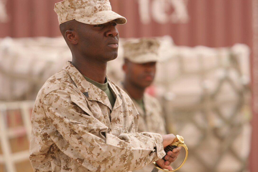 Cpl. Ahmed Adeyemi, 22, a switchboard operator with Headquarters Company, Regimental Combat Team 5, returns his noncommissioned officer sword after completing the drill exam for RCT-5â??s corporal course April 16 at Camp Ripper, Iraq.  Despite being deployed to Iraq for a year, RCT-5 held a Corporals Course to instill leadership and confidence into its NCOs.