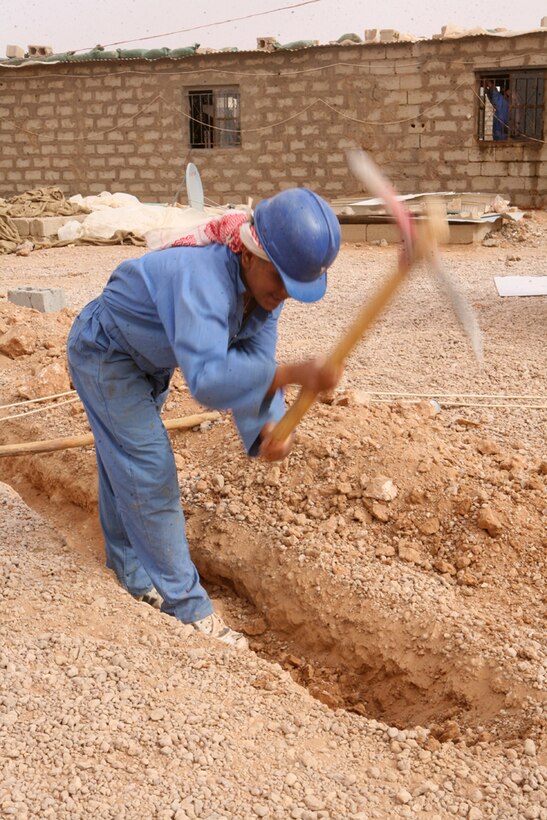 Muhanded Turkay, a construction worker, digs a trench for plumbing systems for a new Iraqi Army compound in Western Al Anbar province, Iraq, April 16. Marines with Task Force Mustang, 2nd Light Armored Reconnaissance Battalion, Regimental Combat Team 5, have been conducting security operations to ensure workers of the compound are able to work without the worry of being in danger.