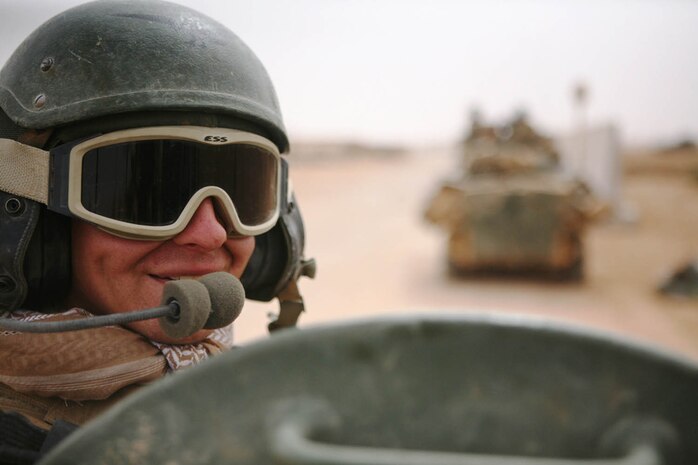 Cpl. Sean P. Whitaker, a vehicle commander with Delta Company, 2nd Light Armored Reconnaissance Battalion, Regimental Combat Team 5, converses with a scout in his vehicle while preparing for a patrol through western al-Anbar province at Camp Korean Village, Iraq, April 16. After completing a successful tour in Iraq, the Marines and sailors of 2nd LAR Bn. will return home to the United States.::r::::n::