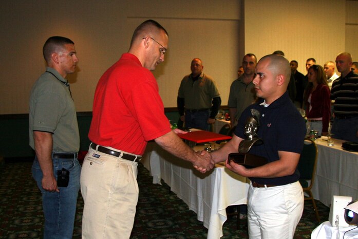 Staff Sgt. Roberto Rivera , staff noncommissioned officer in charge of Recruiting Substation Grand Rapids North, shakes hands with Col. Jeffery Peterson, the commanding officer of 9th Marine Corps District, during RS Lansing's Centurion award ceremony  April 18.