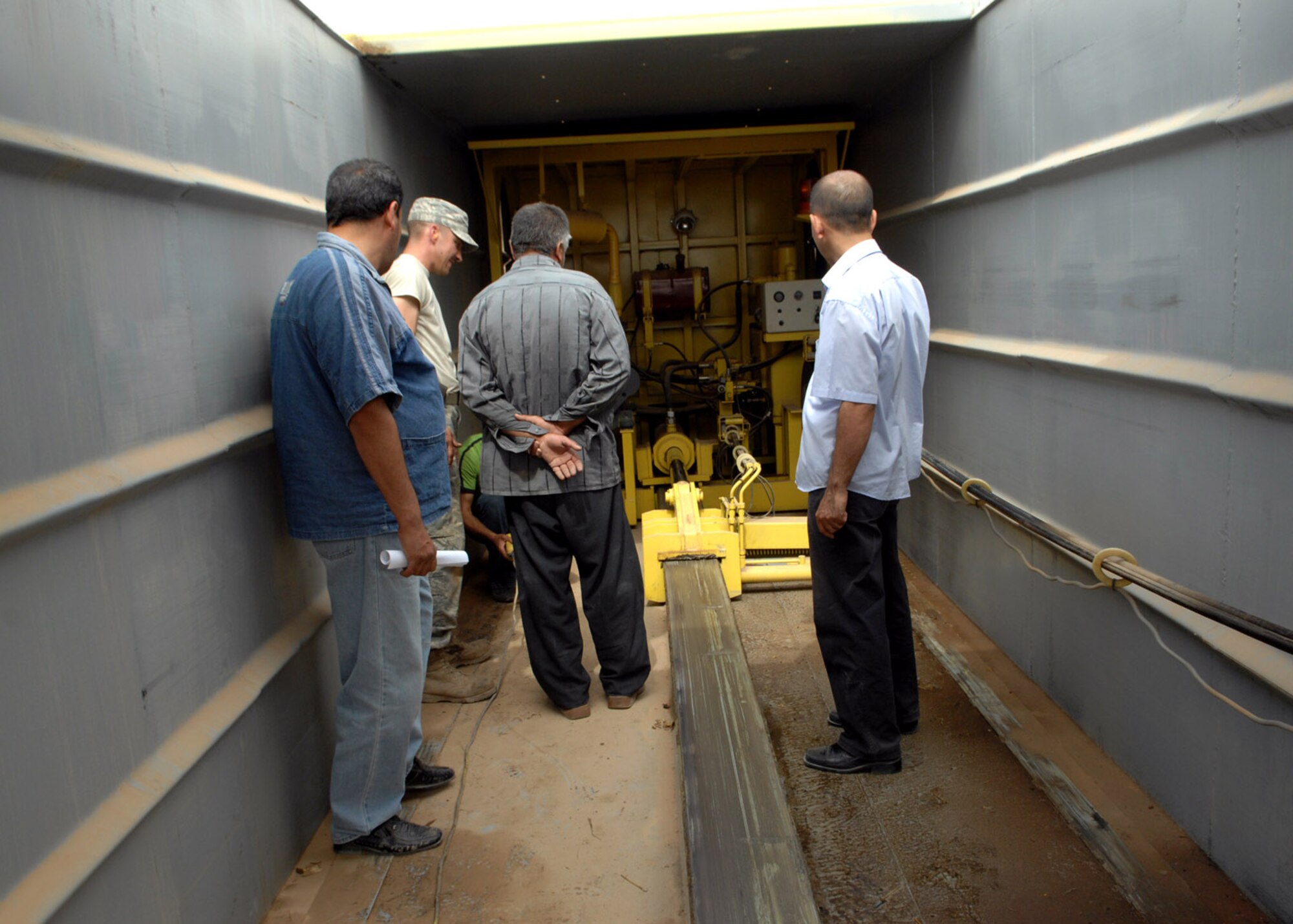 Airmen from the 506th Expeditionary Logistics Readiness Squadron help train local Iraqis on preventative vehicle maintenance from inside a truck. The 506th ELRS Vehicle Management Flight teamed with Kirkuk's Provicinal Reconstruction Team to train 11 Iraqis on proper maintenance techniques for newly acquired equipment the Municipality of Kirkuk will use for waste management. (U.S. Air Force photo by Senior Airmen SerMae Lampkin)