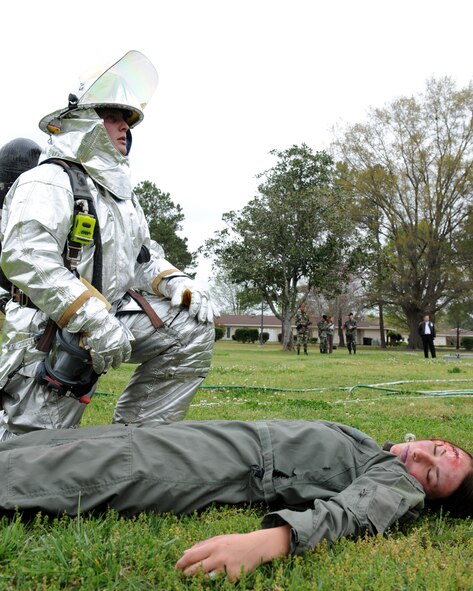 SEYMOUR JOHNSON AIR FORCE BASE, N.C. - A firefighter from the 4th Civil Engineering Squadron kneels at the side of a casualty during the Major Accident Response Exercise (MARE)  April 9, 2008. The 4th Medical Group coordinated with the fire department to ensure they can respond efficiently if something similar happened during real-world events. (U.S. Air Force photo by Airman 1st Class Salma Din)