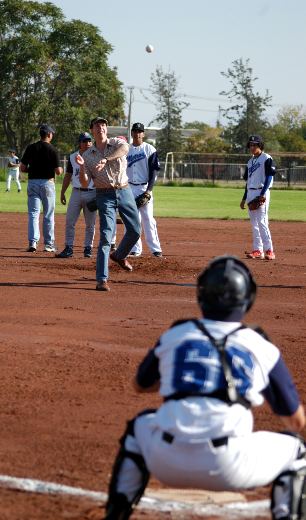 SANTIAGO, Chile -- U.S. Ambassador to Chile Paul Simons throws out the first pitch of a baseball game between American Airmen and Chilean Little Leaguers April 5.  The Chileans won the informal event 8-5.  During the game, the Air National Guard Band of the Central States played music, and dozens of shirts donated by the Colorado Rockies were given to children and fans. (U.S. Air Force photo/Master Sgt. Jason Tudor)