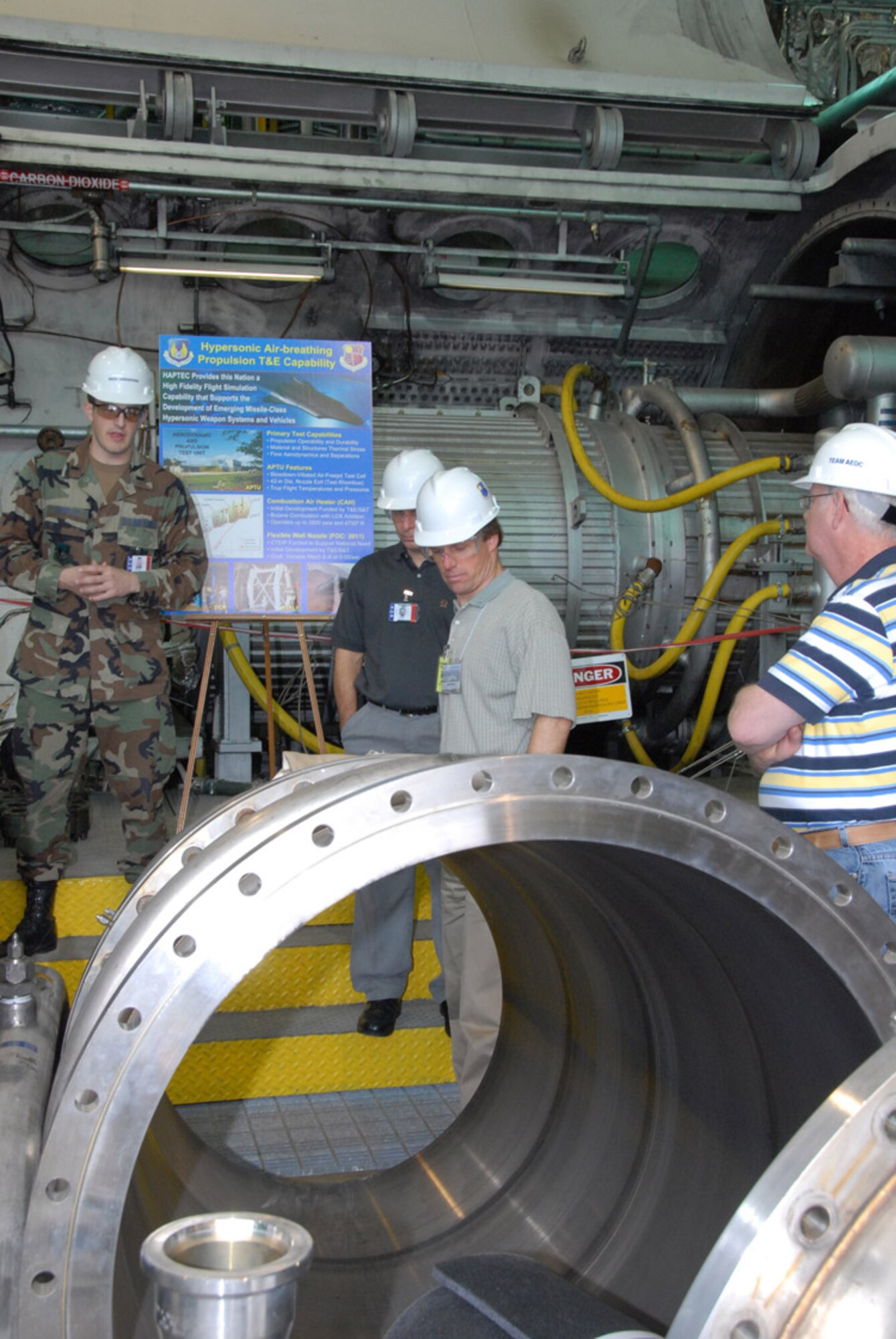 First Lt. Ryan Hawley briefs a group of 44 people in Aerodynamic Propulsion Test Unit (APTU) who toured Arnold Engineering Development Center (AEDC) last week. The visitors are Transonic, Supersonic and Hypersonic wind tunnel members of the Supersonic Tunnel Association International (STAI). The STAI semi-annual conference was held in Nashville and part of the conference was to tour AEDC facilities to better understand their operation and capabilities. AEDC personnel have been a STA/STAI members since the first meeting in 1954 in Texas. The visitors included key personnel from NASA and other U.S. wind tunnel facilities in addition to international representatives. (Photo by David Housch)