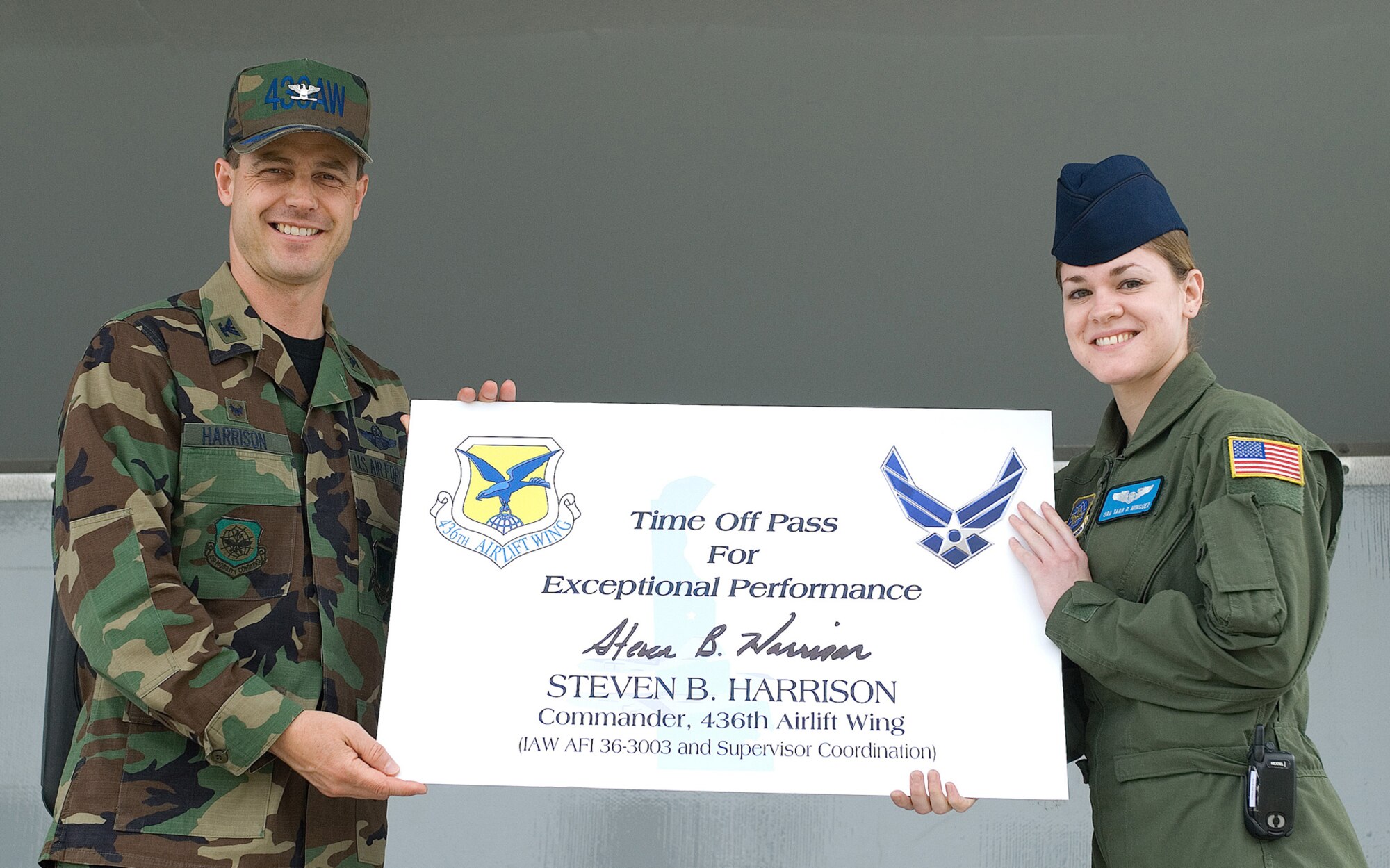 Col. Steven Harrison presents a time off pass for exceptional performance during the Installation Excellence Selection Board visit.  Senior Airman Tara Minguez, 9th Airlift Squadron, accepted the pass on behalf of the Airmen of Team Dover at the Installation Excellence Appreciation Burger Burn April 11. (U.S. Air Force Photo/Roland Balik)