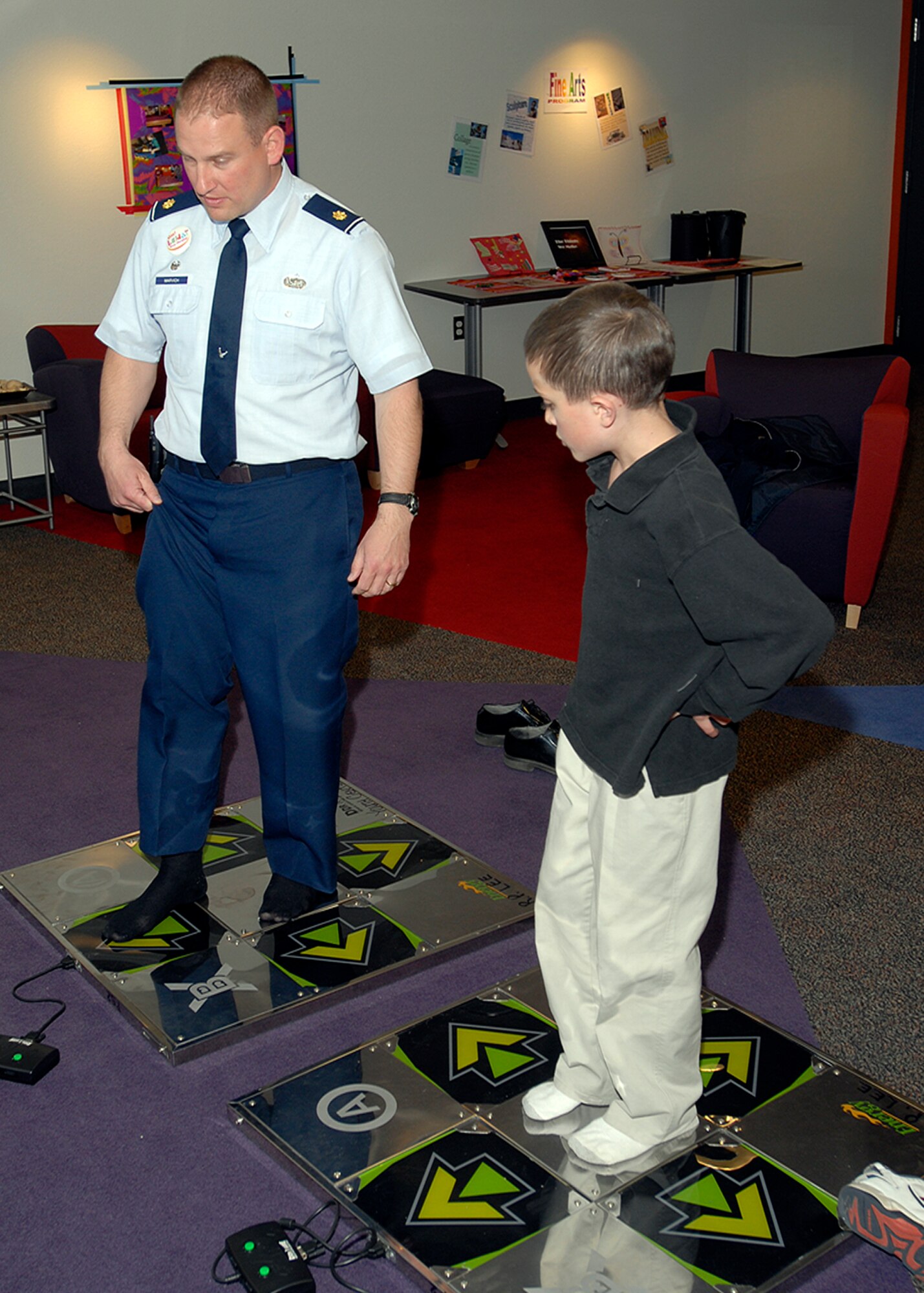 Maj. Mike Marvich, 21st Services Squadron commander, experiences the R.P. Lee Youth Center's 'Dance Dance Revolution' gaming system with a Peterson youth April 8. The team inspected the 21st Services Squadron April 7-11 at this Colorado base to see if they qualified as the “best of the best” of services squadrons throughout the Air Force. (U.S. Air Force photo/Robert Lingley)