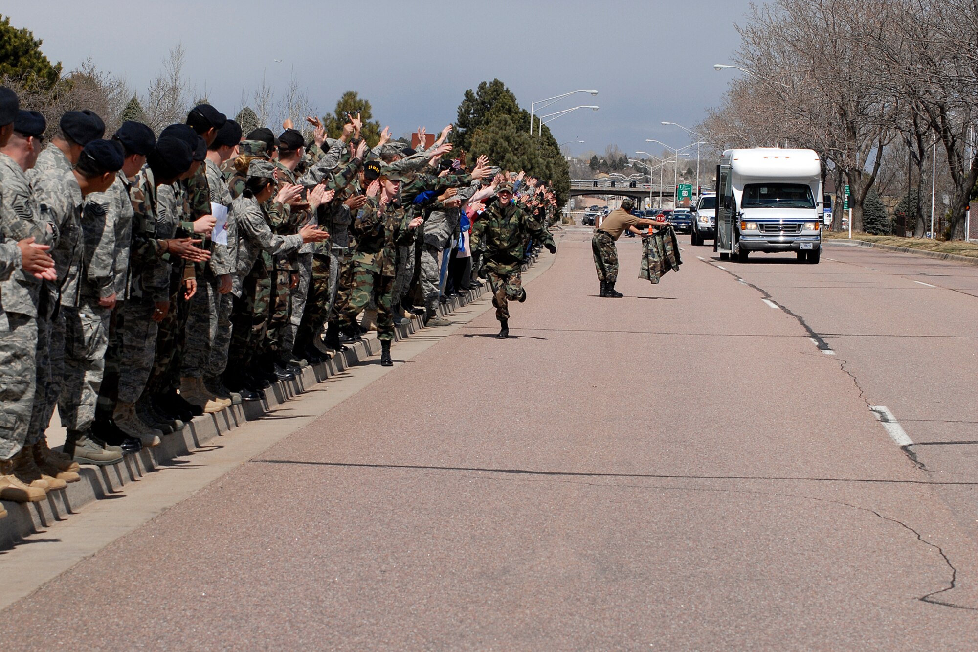 Members of the 21st Space Wing greet in mass the Air Force-level Gen. Curtis E. LeMay Services inspection team inside the North Gate at Peterson Air Force Base, Colo., April 7. The team inspected the 21st Services Squadron through April 11 to see if they qualified as the “best of the best” of services squadrons throughout the Air Force. (U.S. Air Force photo/Rob Bussard)