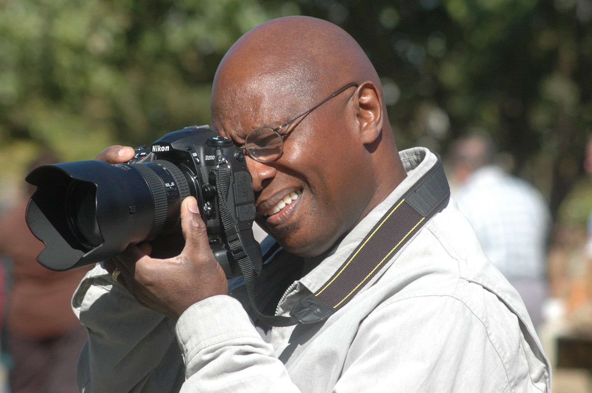 Ray Crayton, lead photographer shoots a photo on an assignment. U. S. Air Force photo by Sue Sapp