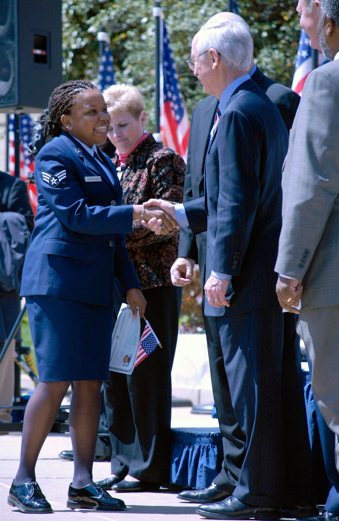 Senior Airman Cassandra Obermuller Brandon (left) accepts her naturalization certificate from Deputy Secretary of Defense Gordon England during a naturalization ceremony April 14 in the Pentagon's center courtyard. More than 20 servicemembers became American citizens during the ceremony. Airman Brandon, who was born and raised in Guyana, moved to the United States with her father in 1991 and joined the Air Force Reserve in 2002. (U.S. Air Force photo/Staff Sgt. Julie Weckerlein)