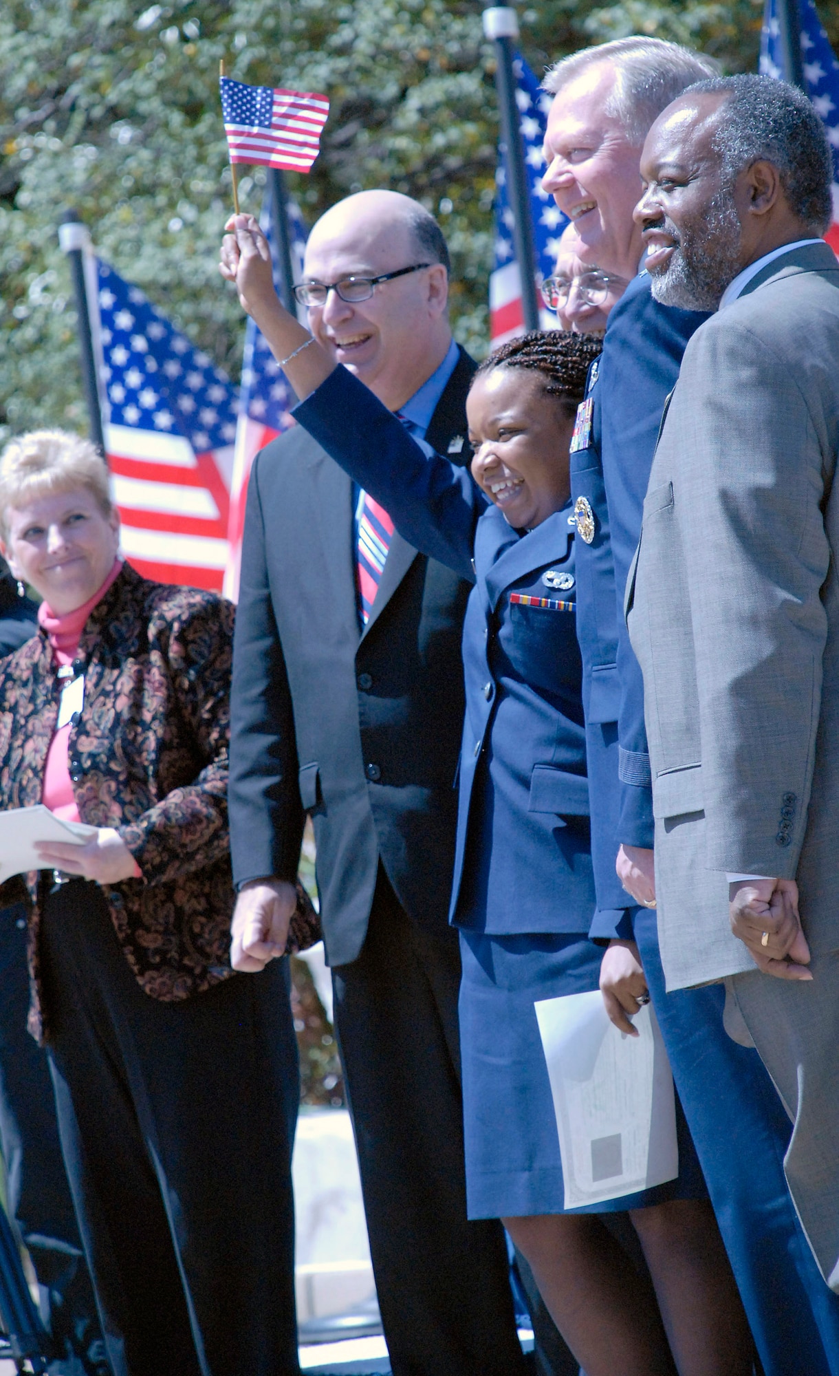 Senior Airman Cassandra Brandon raises the American flag after accepting her naturalization certificate during a naturalization ceremony April 14 in the Pentagon's center courtyard. More than 20 servicemembers became American citizens during the ceremony. Airman Brandon, who was born and raised in Guyana, moved to the United States with her father in 1991 and joined the Air Force Reserve in 2002. (U.S. Air Force photo/Staff Sgt. Julie Weckerlein) 