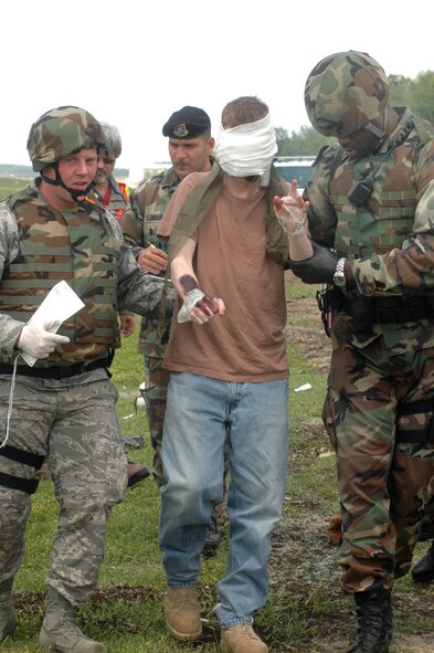 Emergency responders lead an injured victim to an ambulance during an ORI exercise simulating a mid-air collision between a C-130 and an F-15 April 15. U. S. Air Force photo by Sue Sapp