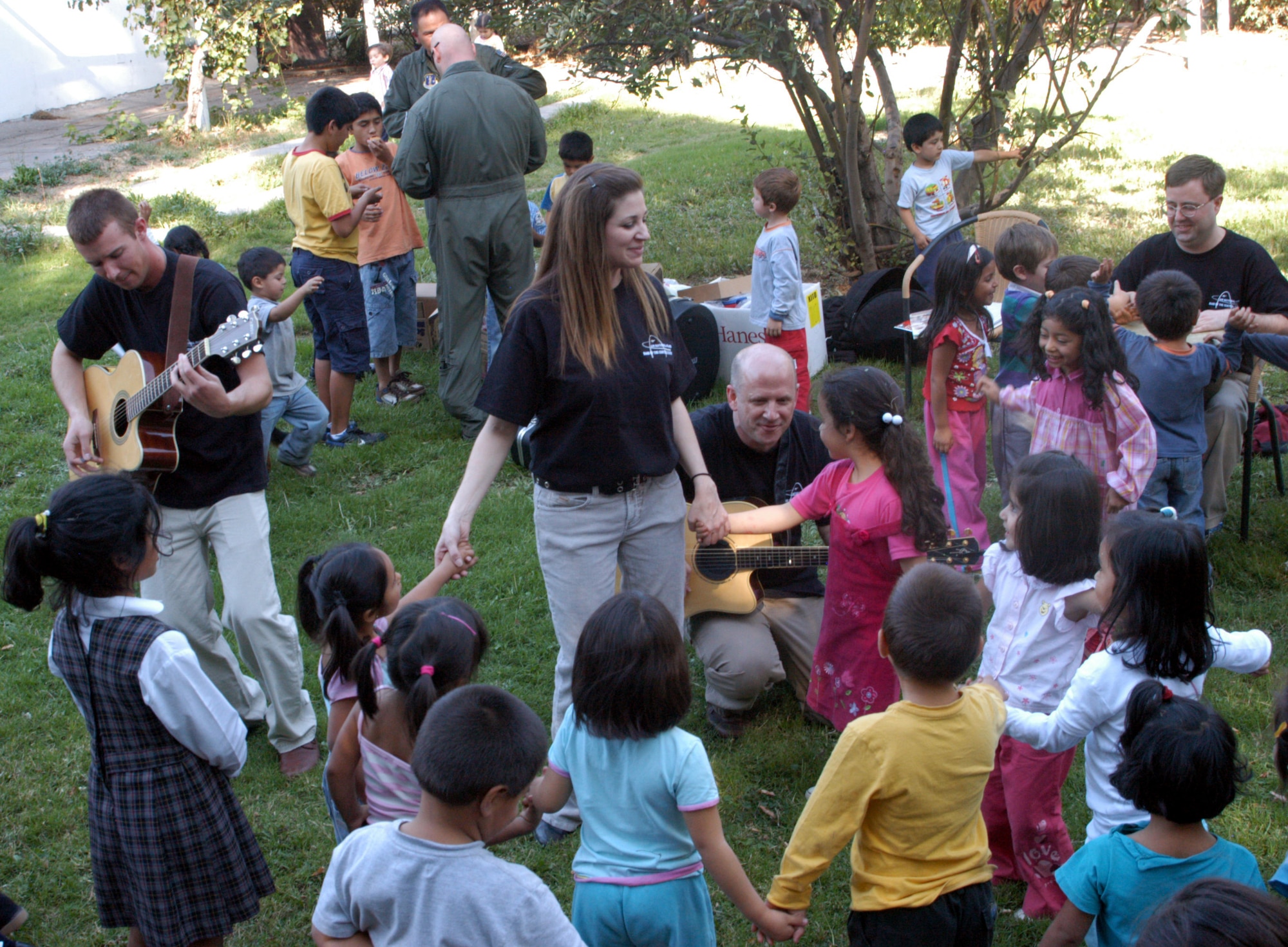 SANTIAGO, Chile -- Children from a local orphanage here dance with lead singer Tech. Sgt. Christin Foley and members of the Air National Guard Band of the Central States Monday, March 31.  The band as well as Airman from the Arizona Air National Guard and F-15E Strike Eagle demonstration team took a break from duties during FIDAE 2008, an international air show, to visit with about 60 children from the orphanage.  The Airmen also handed out toys, stickers, patches and Girl Scout cookies. (U.S. Air Force photo/Master Sgt. Jason Tudor)