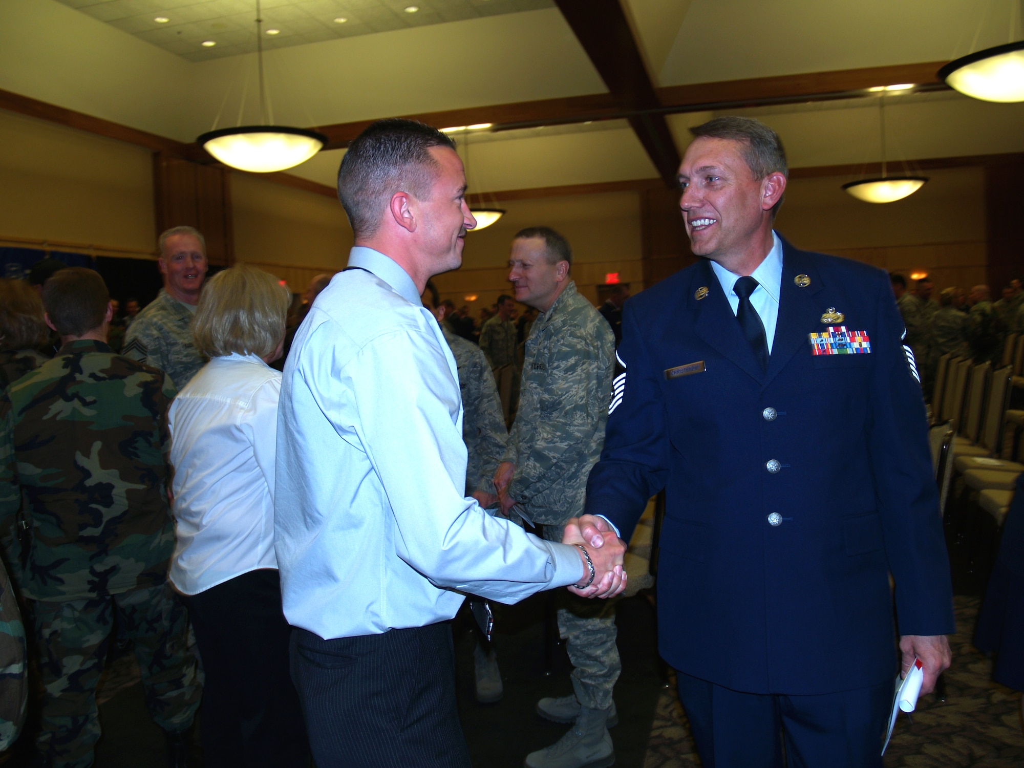 Staff Sgt. Matthew Mason, left, congratulates Master Sgt. Jon Christensen on receiving his degree from the Community College of the Air Force at the graduation commencement April 15 at Club Hill. The 419th Fighter Wing had 17 graduates this semester. 