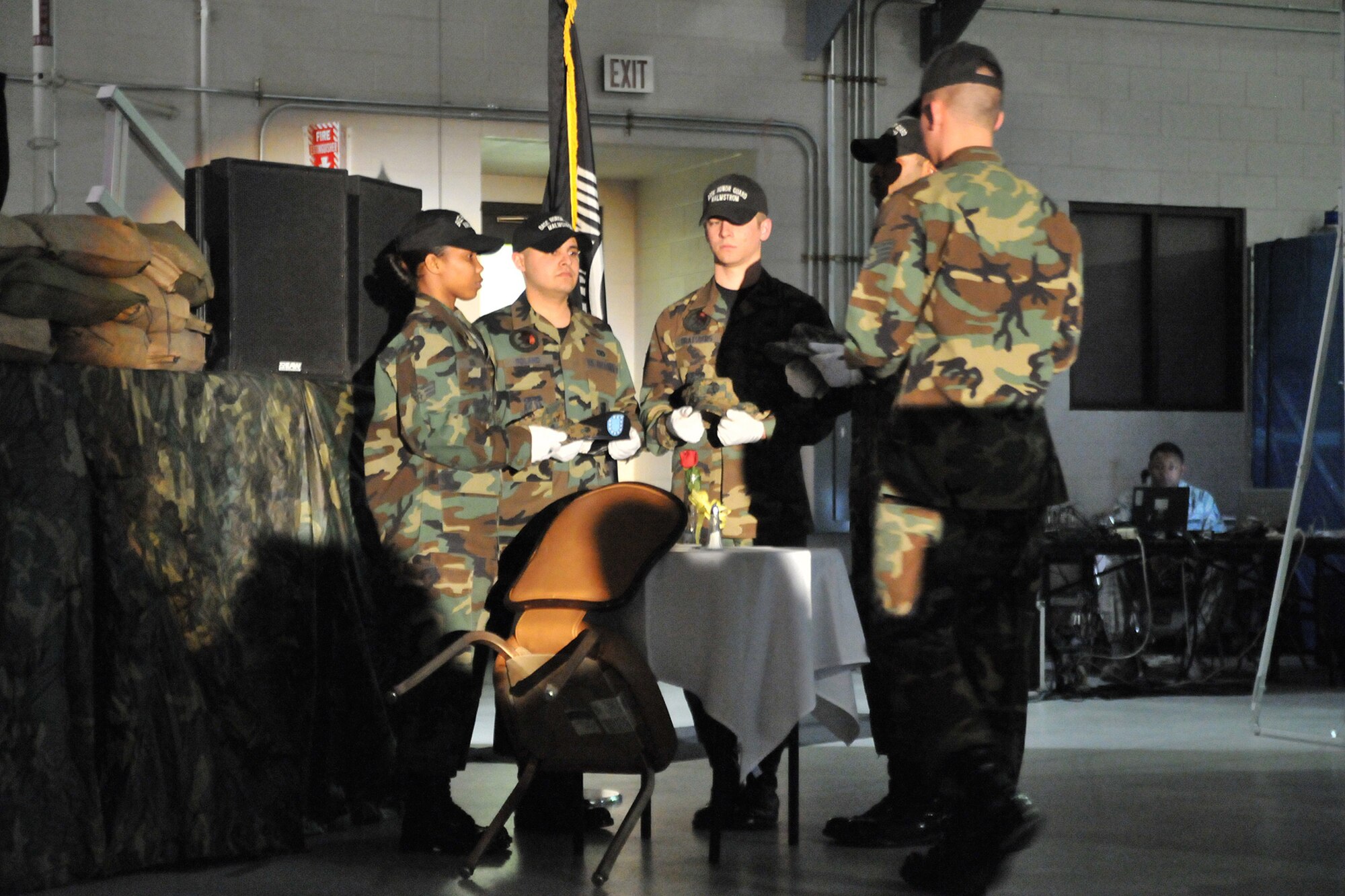 Members of Malmstrom's honor guard prepare a table during the POW/MIA cermony to honor those warriors who have been taken prisoner of war or are missing in action. The white tablecloth, single red rose, yellow ribbon, slice of lemon with salt, inverted glass and empty chair symbolize the purity of their intentions, our determination to account for our missing warriors, the bitter fate and tears shed for those who have been lost and the emptiness of the prisoners of war and missing in action that cannot be with us. (U.S. Air Force photo/John Turner)