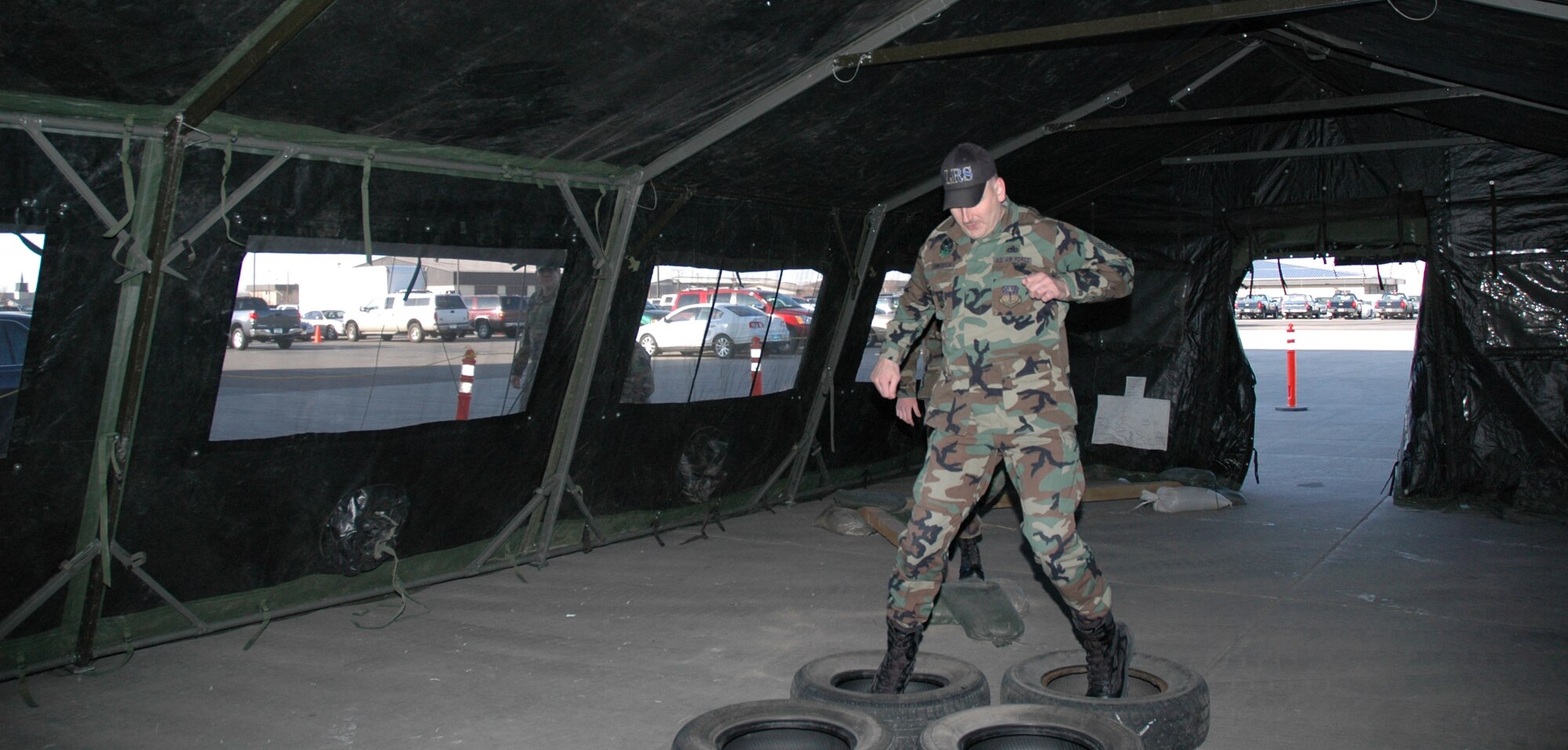 Master Sgt. Shayne Pederson, 341st Logistics Readiness Squadron, negotiates an obstacle course before gaining entrance to the 2008 Enlisted Dining Out April 11. There were a series of tents containing obstacles such as tricycles, paintball guns and tires attendees had the option of overcoming before entering the event. (U.S. Air Force photo/Airman 1st Class Emerald Ralston)