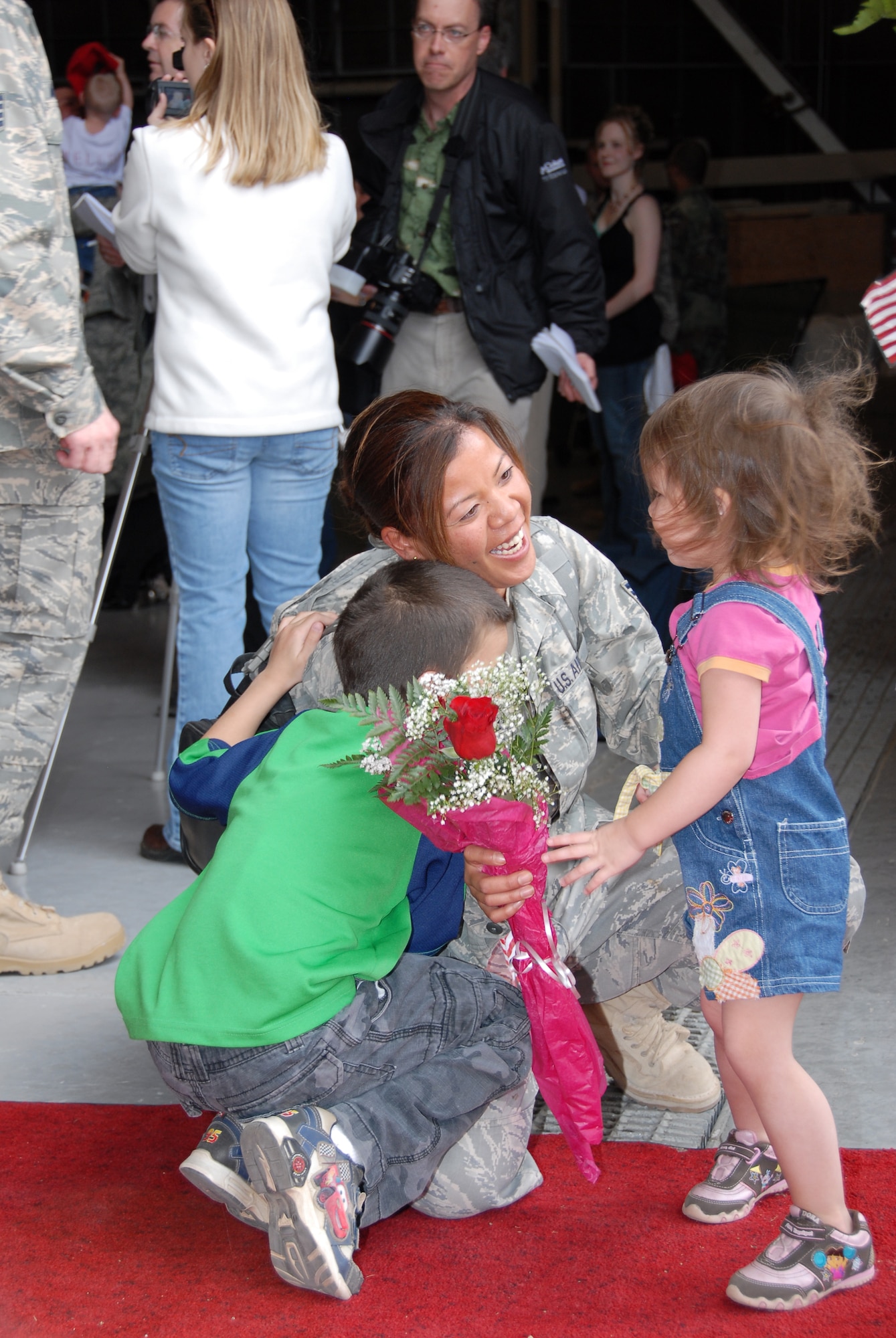 Staff Sgt. Rowena Hawley, 819th RED HORSE Squadron, is greeted by her children with roses and hugs as she returns from a six-month deployment. More than 100 members of the 819th RHS deployed in support of the Global War on Terrorism and returned April 14 to a warm welcome at the RED HORSE Hangar at Malmstrom. (U.S. Air Force photo/John Turner)
