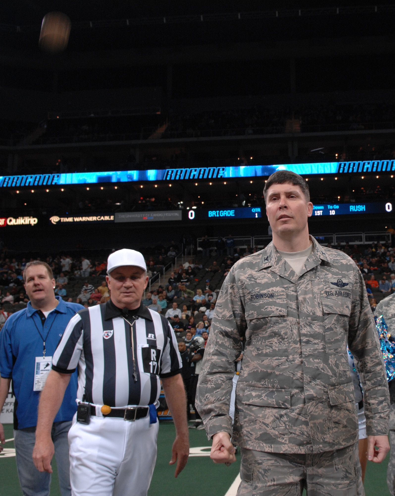 KANSAS CITY, Mo. - . John Robinson, 509th Bomb Wing vice commander, watches the coin fall after performing a coin toss before the Kansas City Brigade versus the Chicago Rush game at the Sprint Arena April 14. The Kansas City Brigade (0-6) lost 49-42 to the Chicago Rush (5-2). The Kansas City Brigade is a team from the Arena Football League. The team got their name Nov. 21, 2005, when the AFL announced the team would be called the Kansas City Brigade.  The team then decided to model their team logo after the B-2. (U.S. Air Force photo/Airman 1st Class Stephen Linch)
