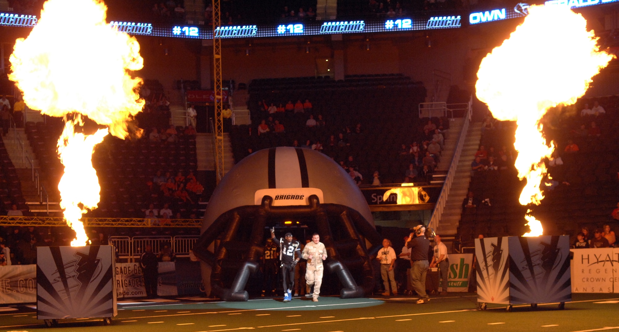 KANSAS CITY, Mo. -  Staff Sergeant Matthew Brown, 442nd Logistics Readiness Squadron, runs onto the field at the Sprint Center with a Kansas City Brigade player April 14. The Kansas City Brigade (0-6) lost 49-42 to the Chicago Rush (5-2). The Kansas City Brigade is a team from the Arena Football League. The team was established before the 2006 season. Former Kansas City Chiefs strong safety, Kevin Porter, is the head coach of the team. (U.S. Air Force photo/Airman 1st Class Stephen Linch)