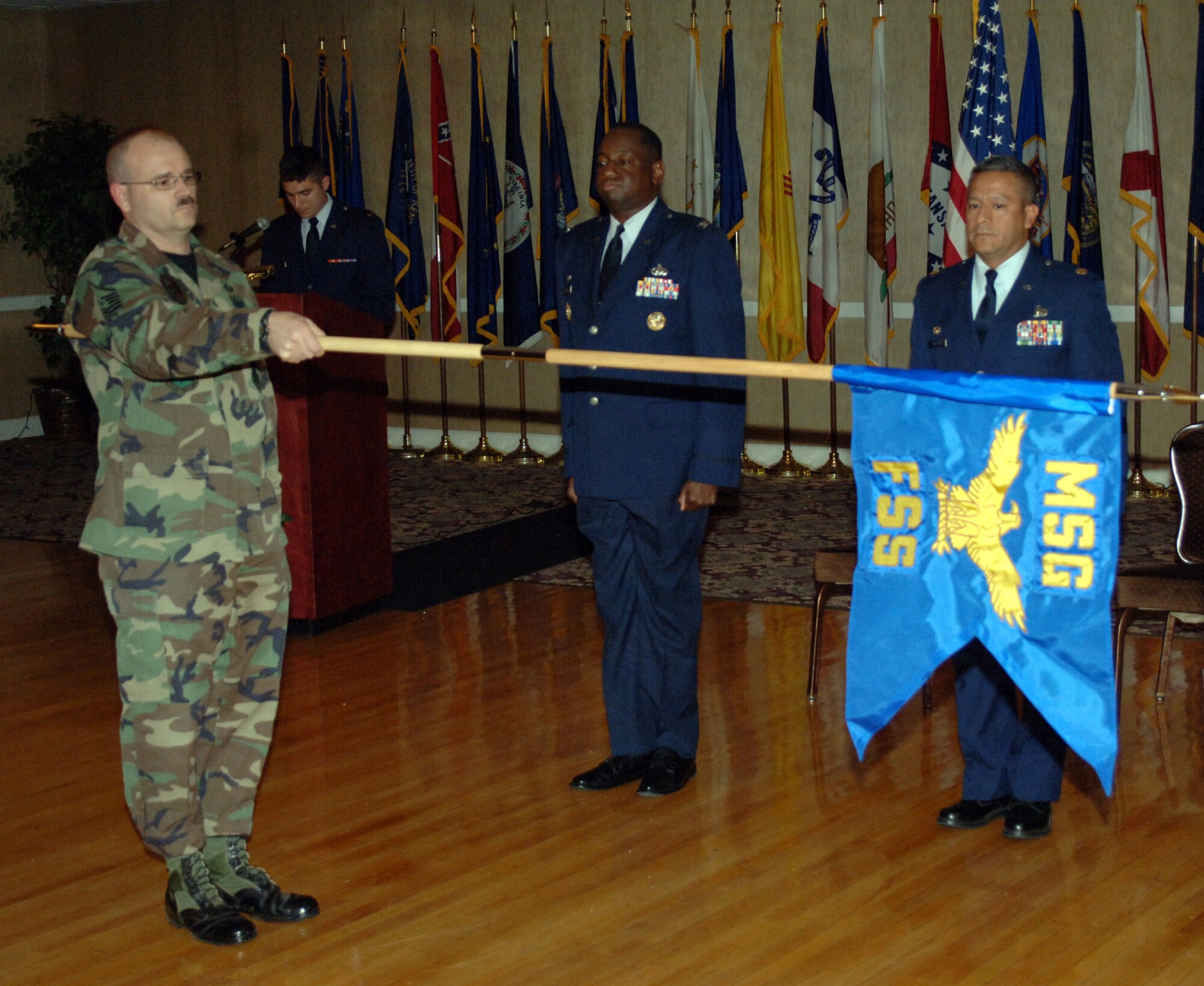 Master Sgt. John Berube unveils the new 14th Force Support Squadron flag at the stand up ceremony Wednesday. The new FSS is a result of the merger of the Services Division and the 14th Mission Support Group. Col. Mark Brown introduced assuming FSS commander, Maj. Jose Aleman, at the event. (U.S. Air Force photo by Airman Josh Harbin)