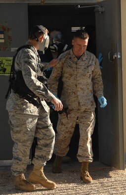 DYESS AIR FORCE BASE, Texas- Staff Sergeant Clayton Greer, Detachment one, walks out of the gas chamber with the assistance of Airman First Class Mathew Moklar, emergency management, April 12. Before a service member can exit the chamber they are required to answer a question to ensure they receive the full affects of the tear gas. (U.S. Air Force photo by Senior Airman Courtney Richardson)
