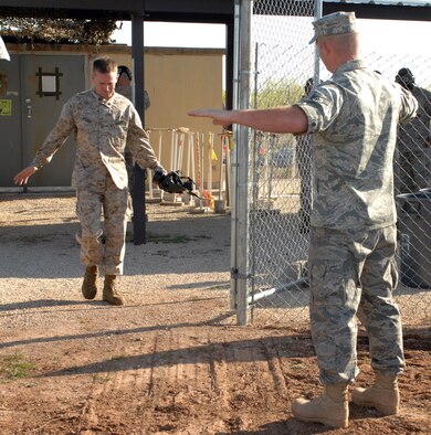 DYESS AIR FORCE BASE, Texas- Corporal Christopher Wright, Detachment 1, exits the gas chamber, while Senior Airman Scott Arrington, emergency management, demostrates the proper recovery techniques, April 12. The best and quickest way to recover from the gas chamber is to walk into the wind and do not touch your face. (U.S. Air Force photo by Senior Airman Courtney Richardson)