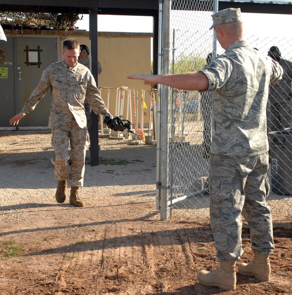 DYESS AIR FORCE BASE, Texas- Corporal Christopher Wright, Detachment 1, exits the gas chamber, while Senior Airman Scott Arrington, emergency management, demostrates the proper recovery techniques, April 12. The best and quickest way to recover from the gas chamber is to walk into the wind and do not touch your face. (U.S. Air Force photo by Senior Airman Courtney Richardson)