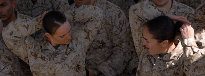 DYESS AIR FORCE BASE, Texas- Lance Corporal's Elizabeth Kersey and Ashley Rodriguez, Detachment 1, take down their hair, April 12. Women who go through the gas mask confidence training are required to take down their hair, so they are not fidgting with it when donning their gas mask. (U.S. Air Force photo by Senior Airman Courtney Richardson)