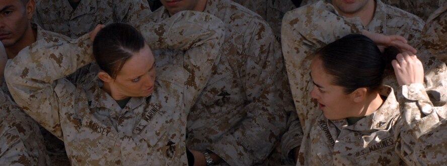 DYESS AIR FORCE BASE, Texas- Lance Corporal's Elizabeth Kersey and Ashley Rodriguez, Detachment 1, take down their hair, April 12. Women who go through the gas mask confidence training are required to take down their hair, so they are not fidgting with it when donning their gas mask. (U.S. Air Force photo by Senior Airman Courtney Richardson)