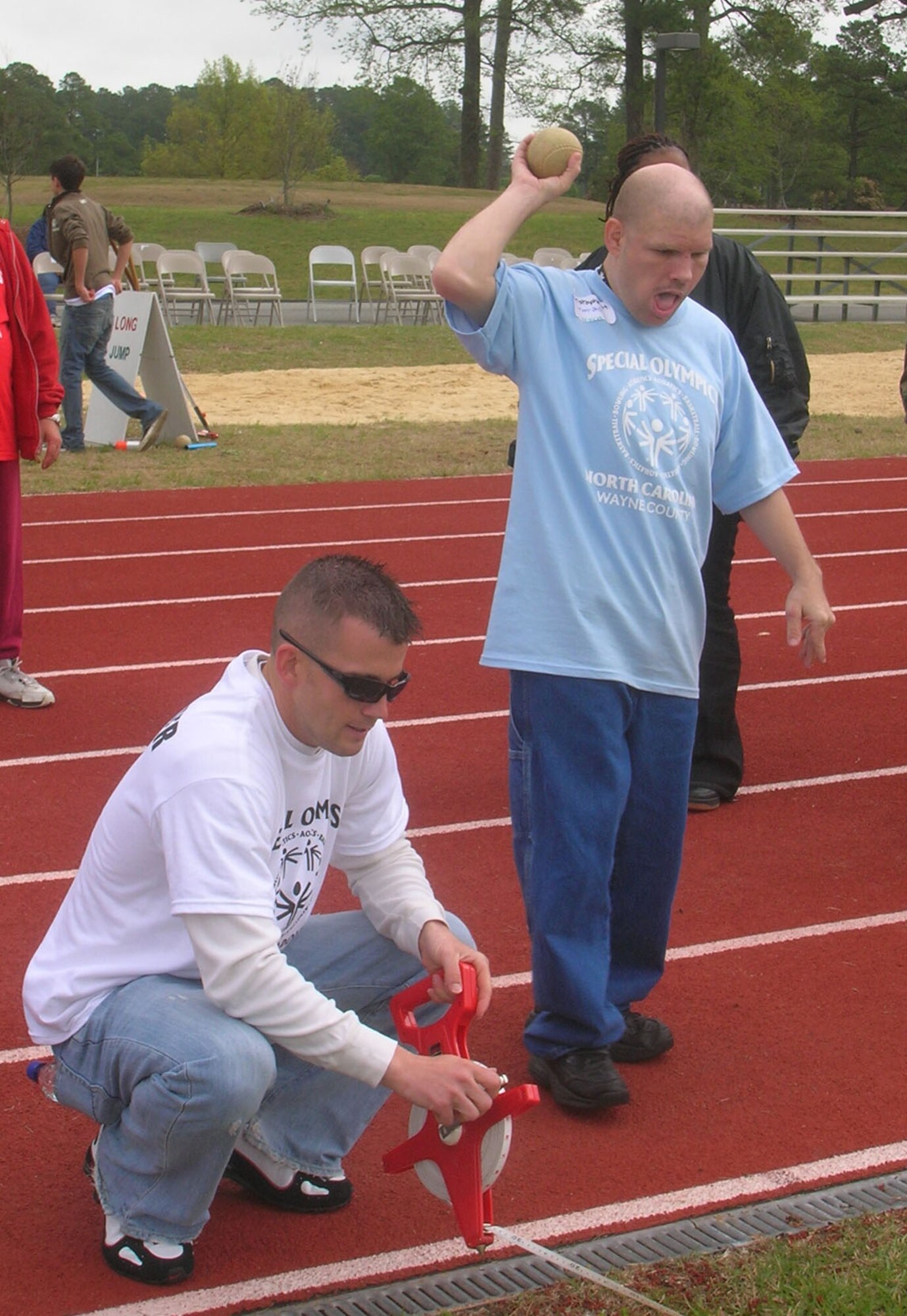 SEYMOUR JOHNSON AIR FORCE BASE, N.C. -- Staff Sgt. Adam Gaither (kneeling) assists with the softball throw at the 2008 Special Olympics Wayne County. The olympics were held on Seymour Johnson Air Force Base and more than 100 athletes participated. Sgt. Gaither is a member of the 916th Security Forces Squadron. Six members of the Air Force Reserve wing participated in the day's events. U.S. Air Force photo/SrA Veronica Odom