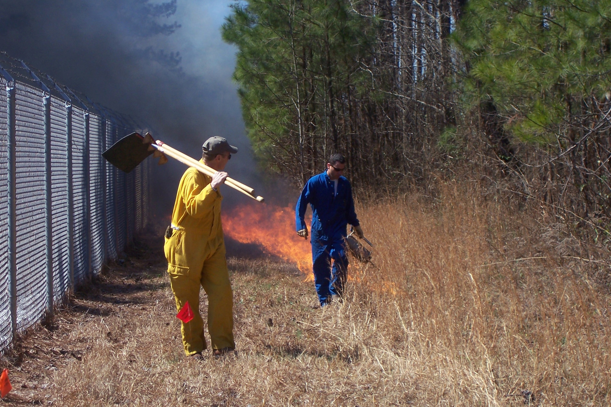 Scott Long, right, a forester with the Army Corps of Engineers begins a burn line during a controlled burn on the south side of Dobbins. A controlled burn is conducted every year to ensure proper forest management and reduce the risk of an uncontrolled forest fire. Nearly 80 acres of brushe were burned. (Air Force photo/Mark Floyd)