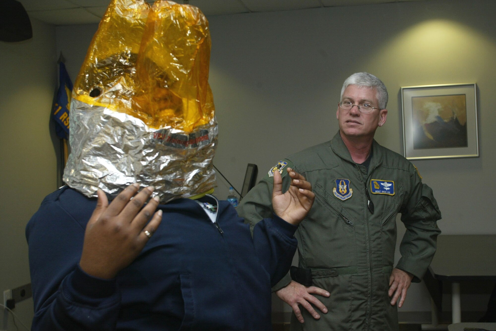 On April 15, Air Force JROTC Cadet Porsher Simmons from Southwest High School, Macon, Ga., demonstrates for her fellow classmates the proper way to wear the emergency passenger oxygen system (EPOS) during a preflight safety briefing conducted by Master Sgt. Gregory Lee. Nearly 1,500 students from area schools took part in orientation flights sponsored by the 94th Airlift Wing. (Air Force photo/Don Peek)